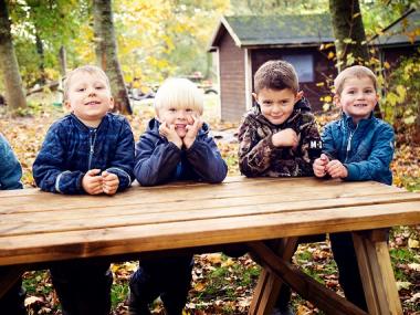 En gruppe glade drenge ved en bænk